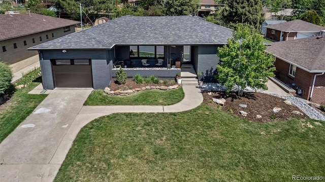4930 Gray St, Denver, CO 80212 - view of front of house with brick siding, driveway, roof with shingles, a garage, and a front yard