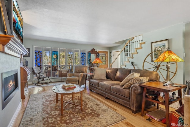 living room featuring light hardwood / wood-style flooring and a textured ceiling