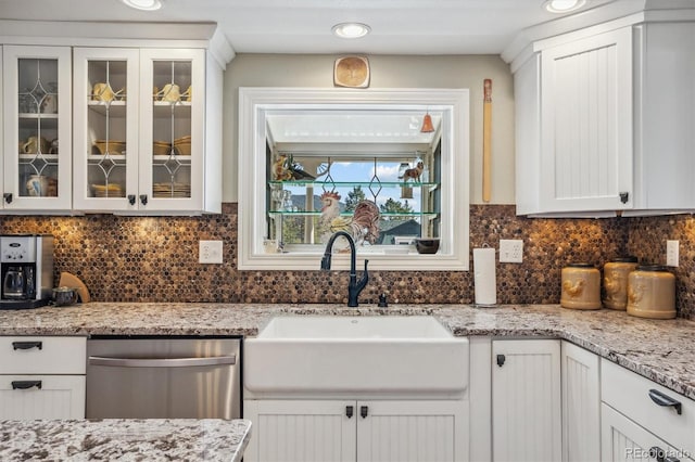 kitchen featuring stainless steel dishwasher, sink, and white cabinets