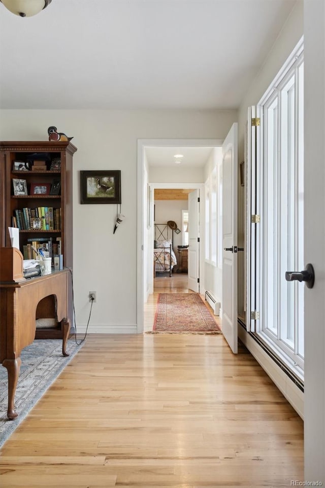 hall featuring light hardwood / wood-style floors and a baseboard heating unit