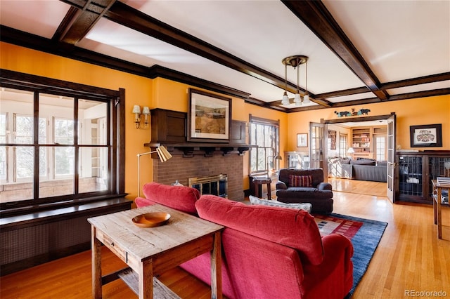 living room with beam ceiling, coffered ceiling, light hardwood / wood-style floors, and a fireplace