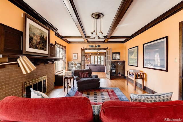 living room with beam ceiling, light hardwood / wood-style floors, a fireplace, and crown molding