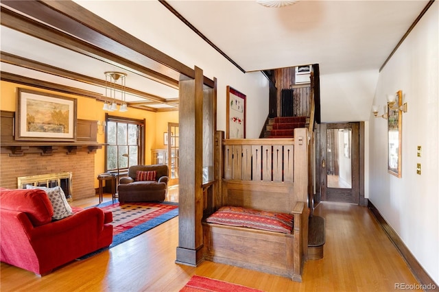 interior space with wood-type flooring, ornamental molding, and a fireplace