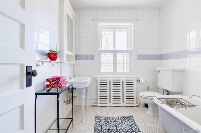 bathroom with tile walls, tile flooring, and toilet