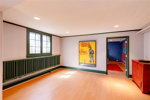 empty room with crown molding and wood-type flooring