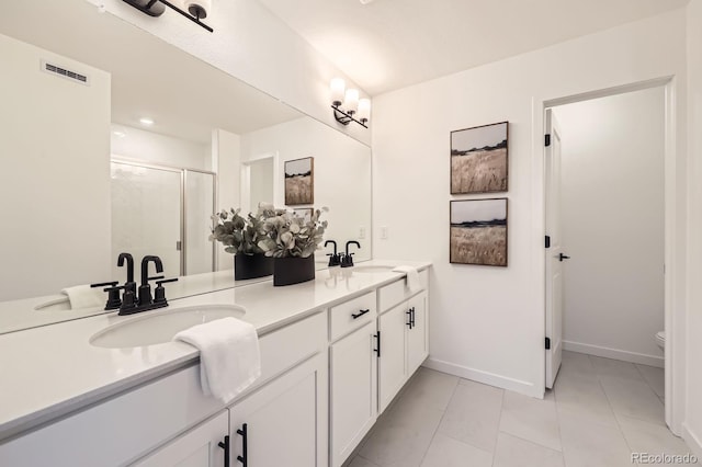 348 N Geneva St, Aurora, CO 80010 - full bathroom with a stall shower, double vanity, tile patterned flooring, toilet, and baseboards