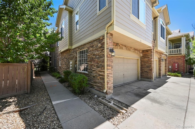 280 Granby Way Unit C, Aurora, CO 80011 - view of side of home featuring a garage, driveway, and stone siding