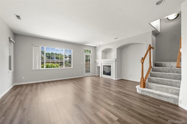 280 Granby Way Unit C, Aurora, CO 80011 - unfurnished living room featuring wood finished floors, stairway, a glass covered fireplace, and recessed lighting
