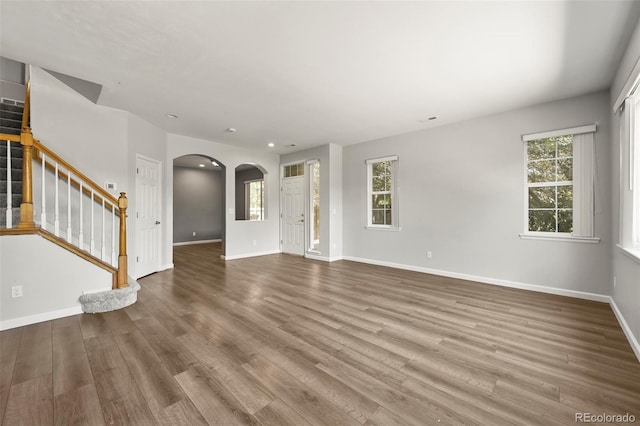 280 Granby Way Unit C, Aurora, CO 80011 - unfurnished living room featuring arched walkways, healthy amount of natural light, wood finished floors, and recessed lighting