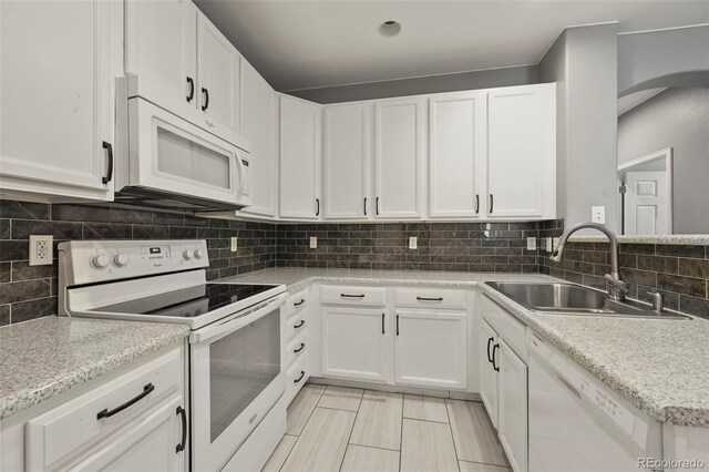 280 Granby Way Unit C, Aurora, CO 80011 - kitchen featuring white appliances, white cabinets, tasteful backsplash, and arched walkways
