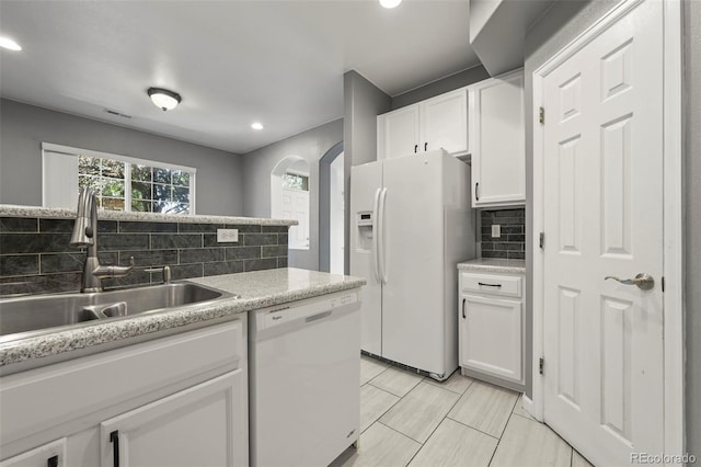 280 Granby Way Unit C, Aurora, CO 80011 - kitchen with white appliances, decorative backsplash, white cabinetry, arched walkways, and recessed lighting