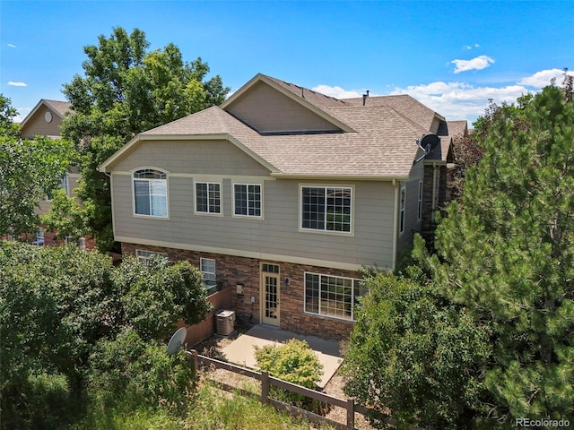 280 Granby Way Unit C, Aurora, CO 80011 - back of property with a patio, a shingled roof, and stone siding