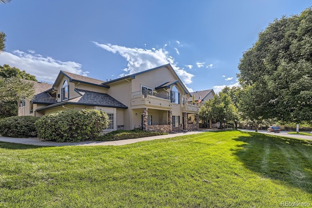 8757 E Dry Creek Rd Unit 1512, Englewood, CO 80112 - view of property exterior featuring stucco siding, a yard, a balcony, and stone siding