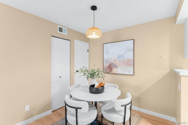 dining area with light wood finished floors and baseboards