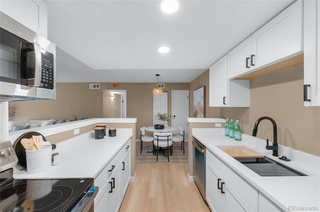 921 S Walden St Unit 205, Aurora, CO 80017 - kitchen with appliances with stainless steel finishes, a sink, light countertops, light wood-type flooring, and recessed lighting