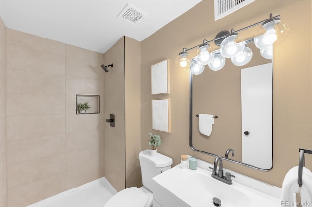 921 S Walden St Unit 205, Aurora, CO 80017 - bathroom featuring toilet, a tile shower, and vanity