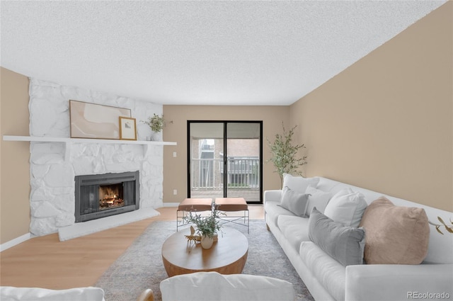 921 S Walden St Unit 205, Aurora, CO 80017 - living room featuring a fireplace, a textured ceiling, wood finished floors, and baseboards