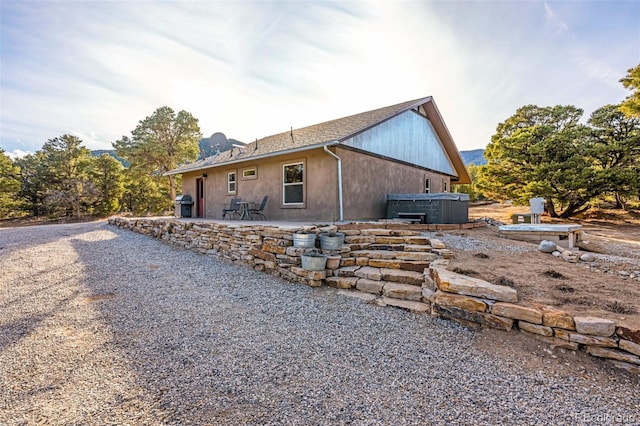 view of side of home with central AC, a hot tub, and a patio