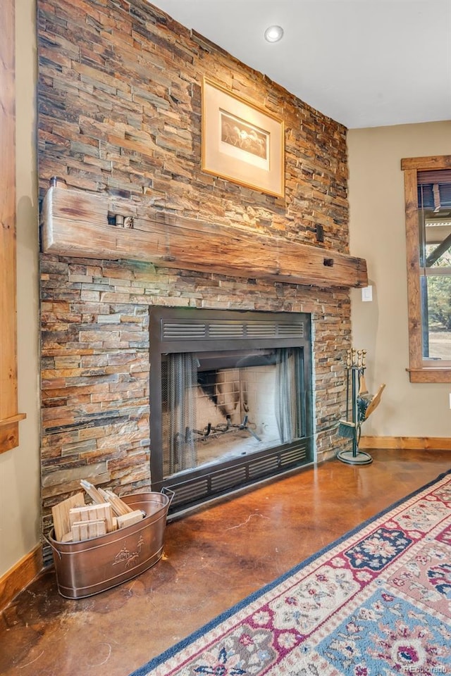 room details featuring concrete floors and a stone fireplace