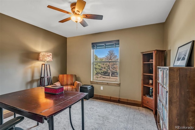 home office with ceiling fan and light carpet