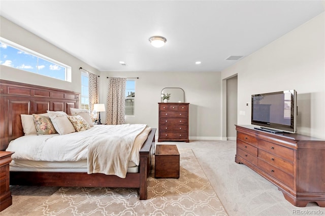 bedroom with baseboards, visible vents, and light colored carpet