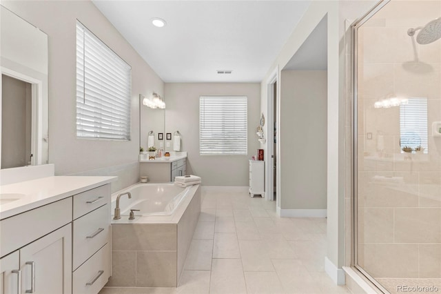 bathroom with two vanities, a stall shower, visible vents, and plenty of natural light