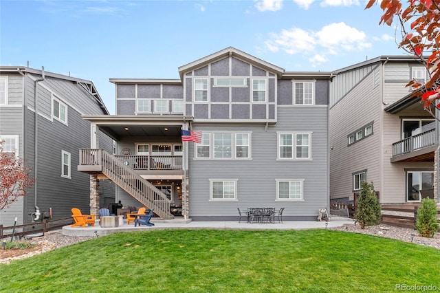 rear view of property featuring stairway, a patio area, and a lawn