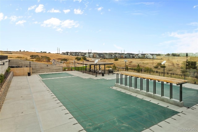 view of swimming pool with fence and a pergola