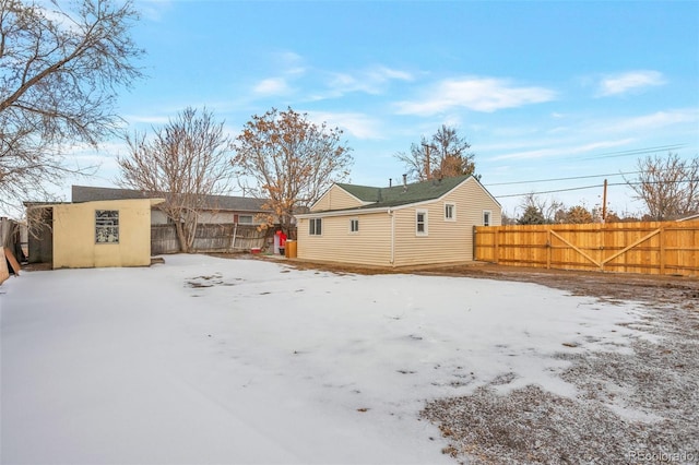 6900 E 66th Ave, Commerce City, CO 80022 - snow covered back of property featuring a fenced backyard and an outdoor structure