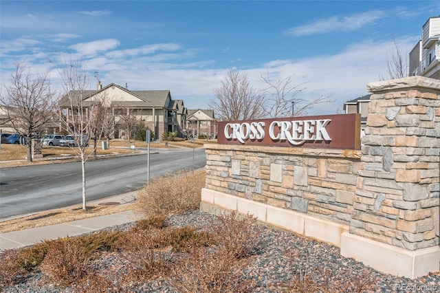 community / neighborhood sign with a residential view