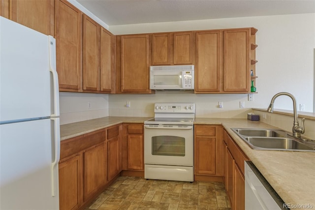 kitchen with white appliances, a sink, light countertops, open shelves, and brown cabinetry