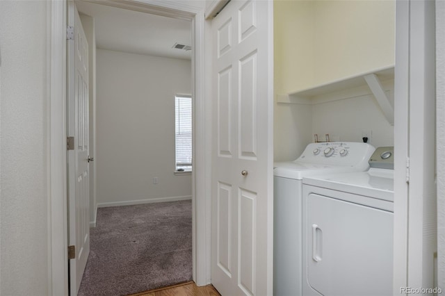 laundry room featuring light colored carpet, washing machine and dryer, visible vents, and baseboards