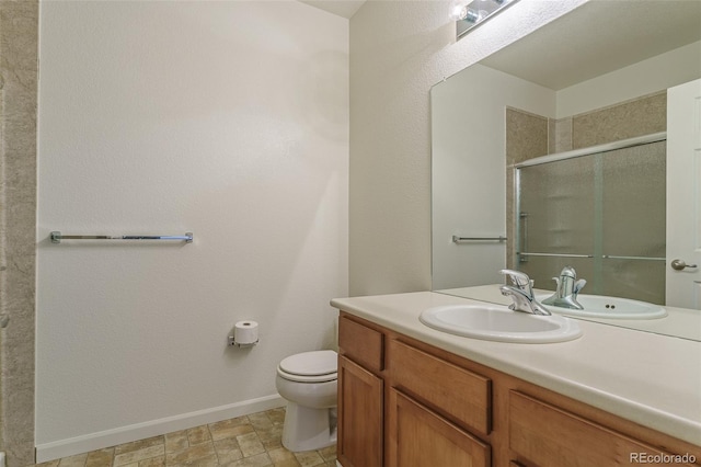 bathroom with baseboards, a shower stall, toilet, and vanity