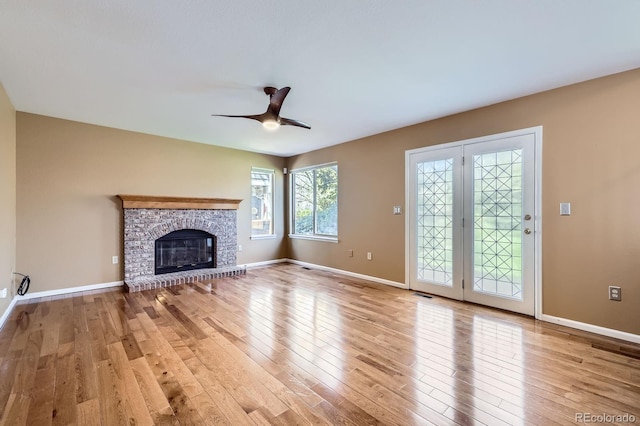 9916 Spring Hill Ln, Highlands Ranch, CO 80129 - unfurnished living room featuring light wood-style flooring, a glass covered fireplace, and a ceiling fan