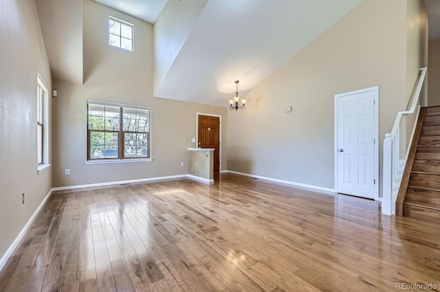 9916 Spring Hill Ln, Highlands Ranch, CO 80129 - unfurnished living room with a towering ceiling, a chandelier, stairs, and hardwood / wood-style floors