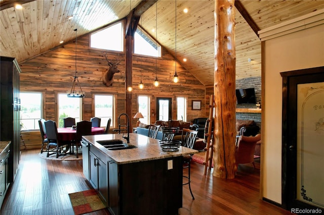 kitchen featuring high vaulted ceiling, sink, an island with sink, and dark wood-type flooring