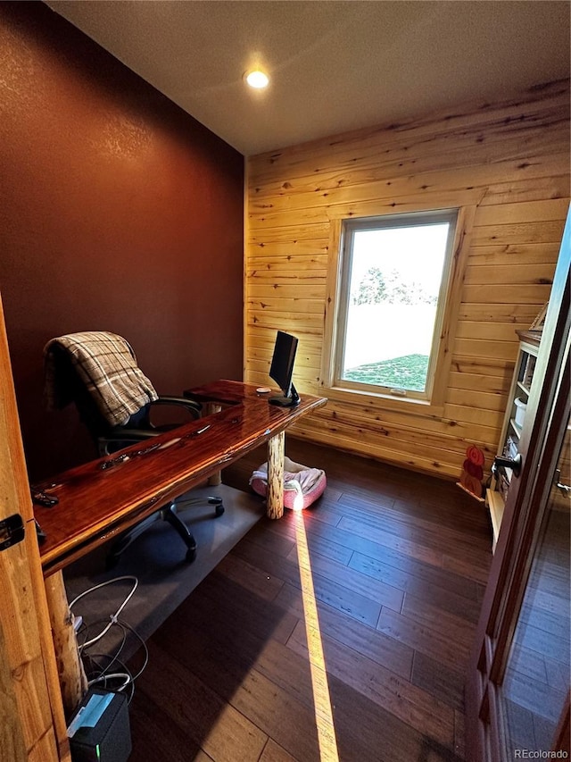 office area with wood-type flooring and wooden walls