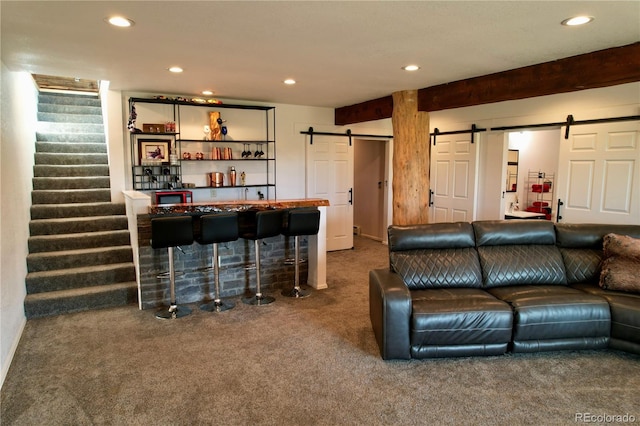 carpeted living room with beam ceiling and a barn door