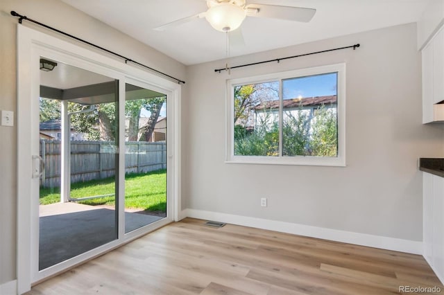 unfurnished dining area with ceiling fan, plenty of natural light, and light wood-type flooring