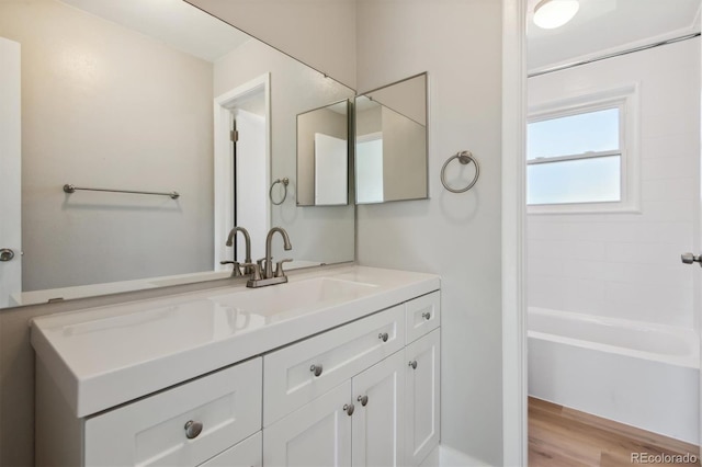 bathroom featuring vanity, hardwood / wood-style floors, and a tub