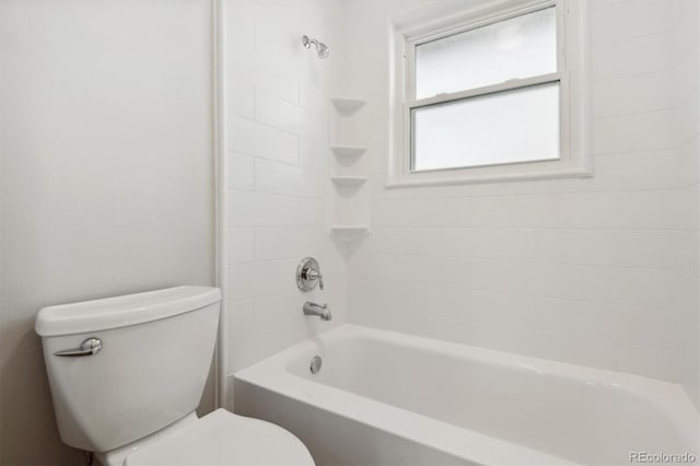 bathroom with tiled shower / bath combo and toilet