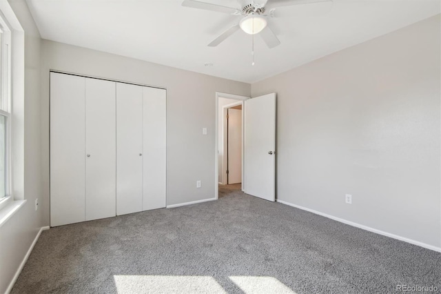 unfurnished bedroom featuring ceiling fan, a closet, and carpet