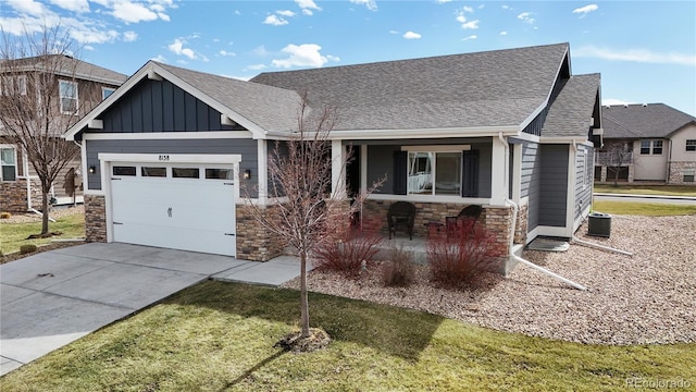 view of front of house with a garage, stone siding, board and batten siding, and concrete driveway