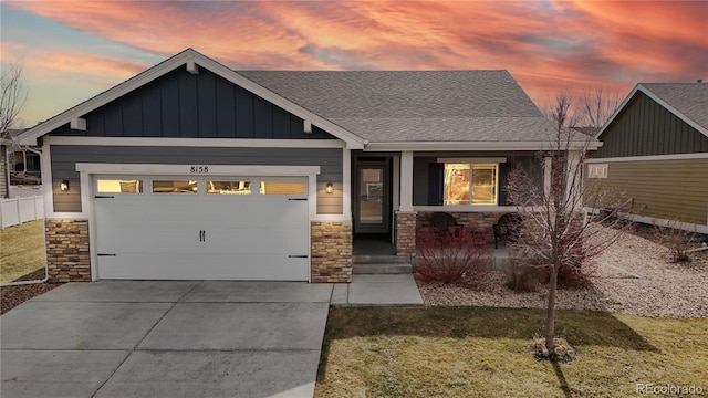 view of front facade featuring board and batten siding, concrete driveway, stone siding, and an attached garage