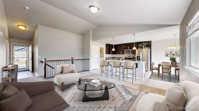 living area featuring lofted ceiling, an inviting chandelier, and baseboards