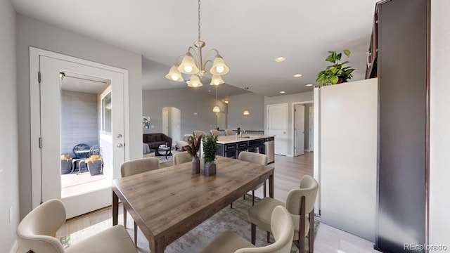 dining room with light wood-style flooring, a chandelier, arched walkways, and recessed lighting