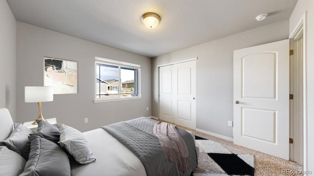 bedroom featuring a closet, carpet flooring, and baseboards