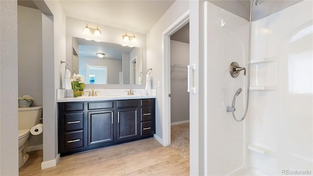 full bathroom with toilet, a sink, double vanity, tasteful backsplash, and walk in shower