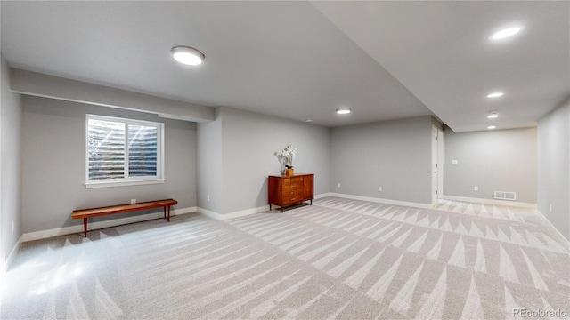 below grade area featuring recessed lighting, baseboards, visible vents, and light colored carpet