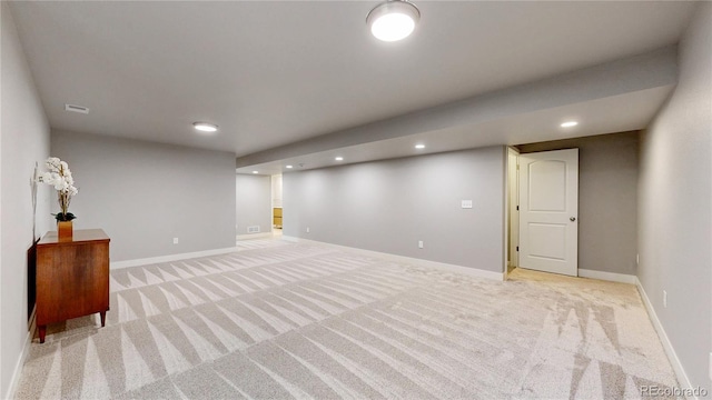 finished below grade area featuring light carpet, recessed lighting, visible vents, and baseboards